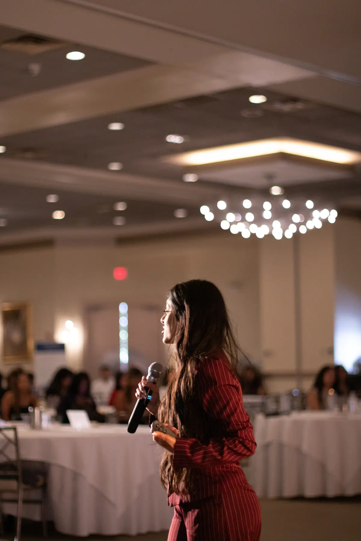Amber Farooqui speaking to an audience in a ballroom