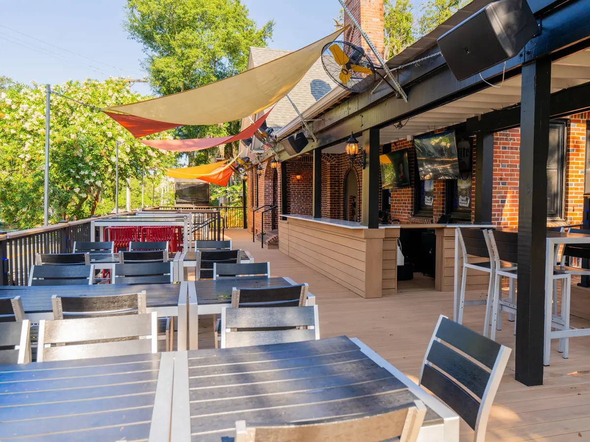 The covered patio with tables and string of TVs