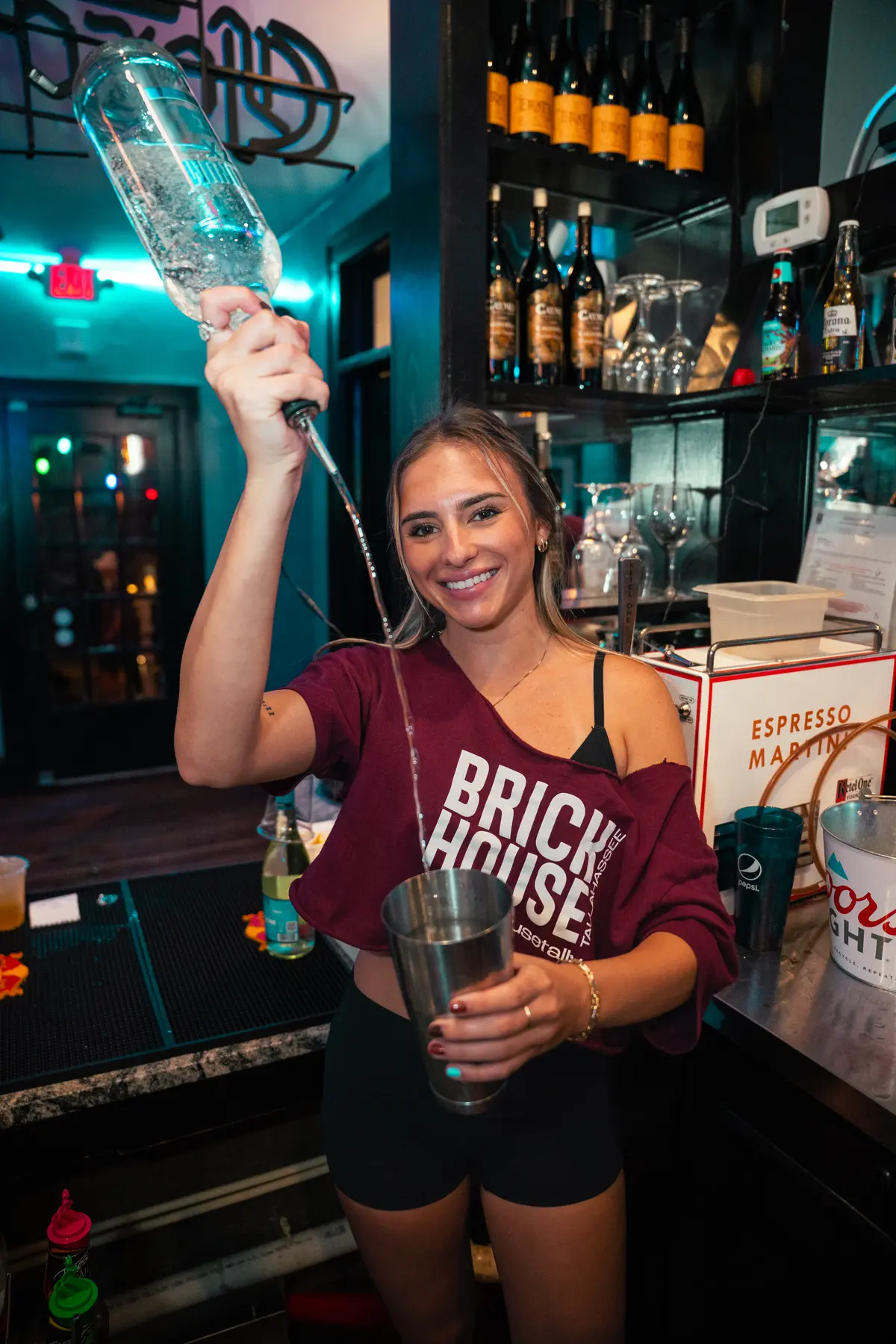 Bartender holding up a bottle behind the bar