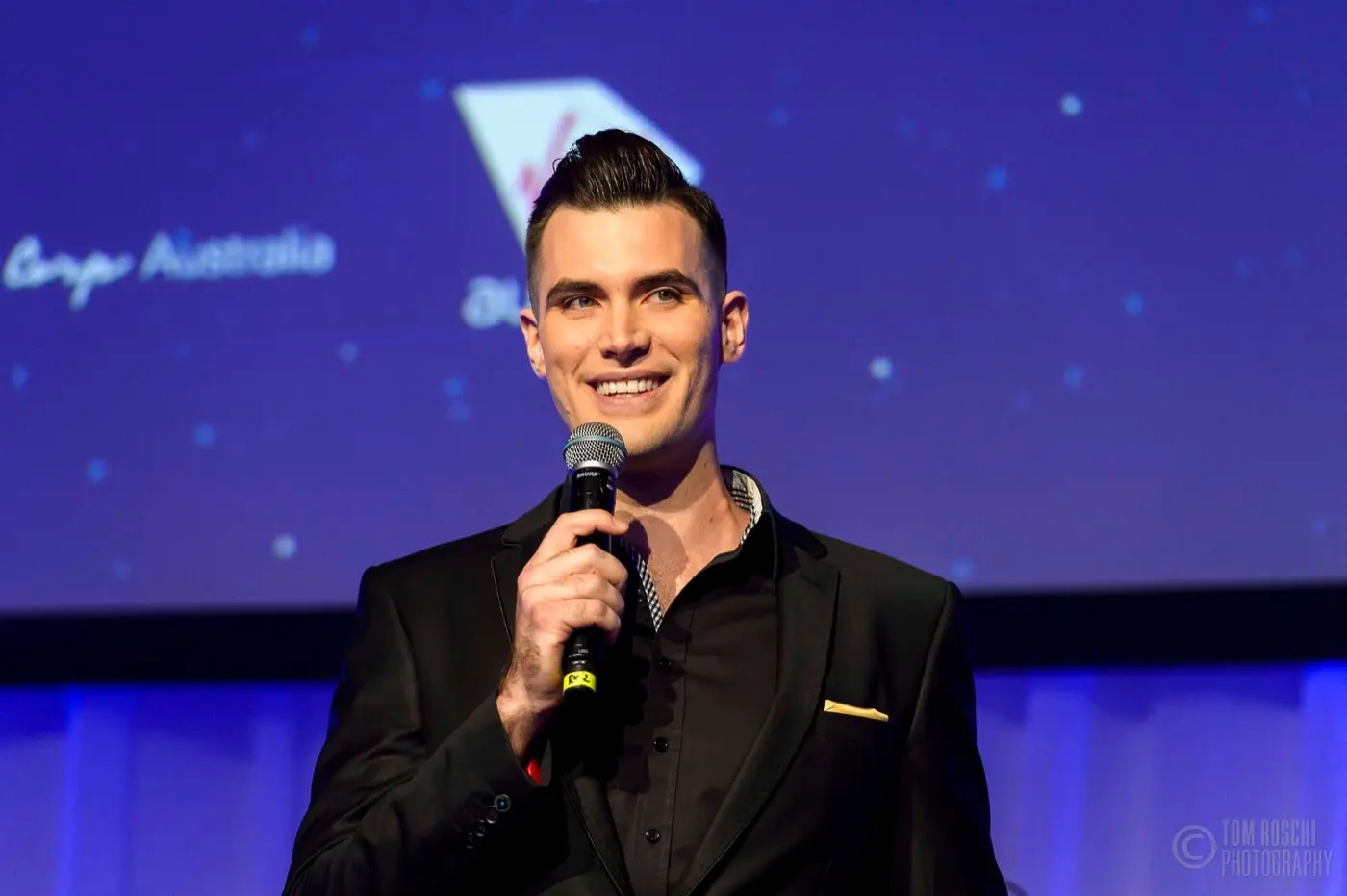 Isaac on stage with a microphone