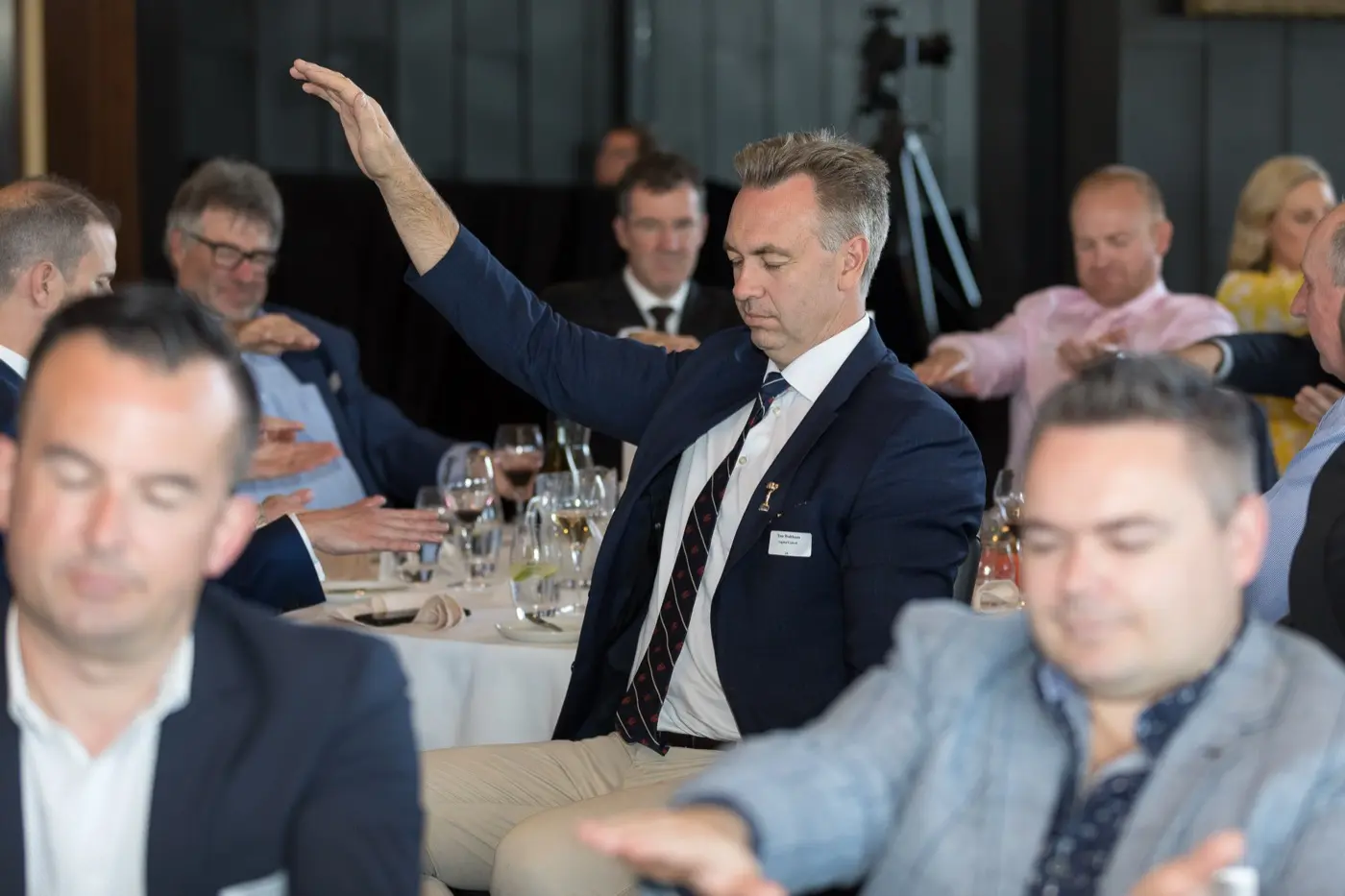 Audience members raising hands during an interactive moment
