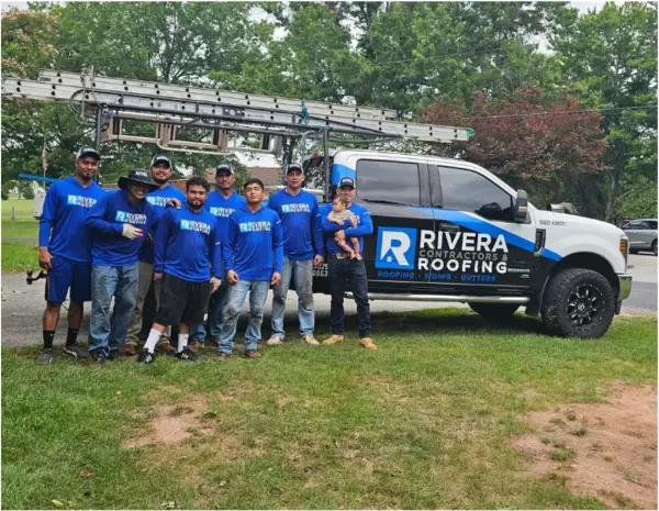 Rivera Roofing crew posing with branded truck, vertical group photo.