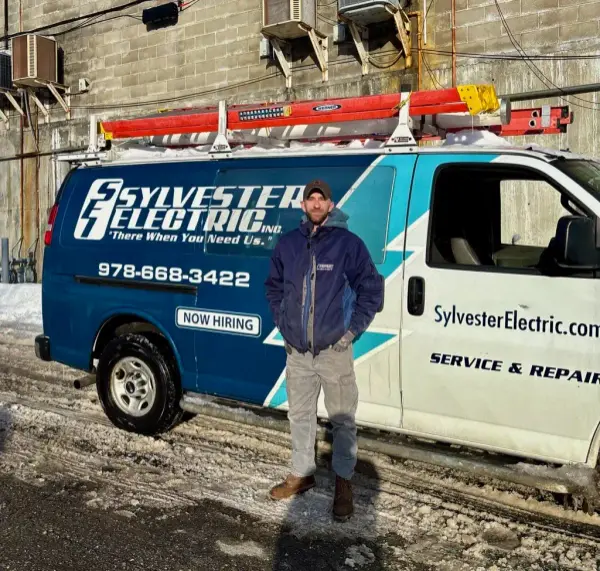 Sylvester Electric technician standing beside a company service van.