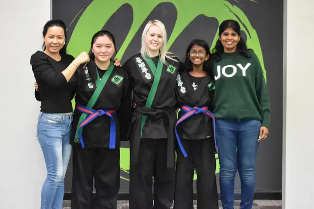 Kids with their families after earning new belts at Fusion