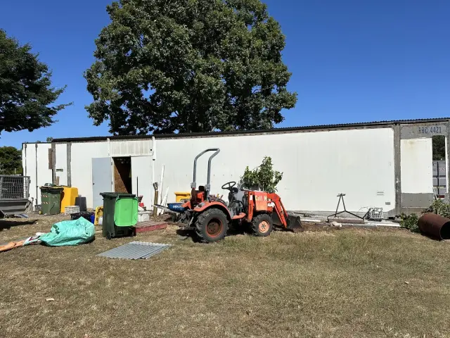 Building site with transportable buildings and a small excavator