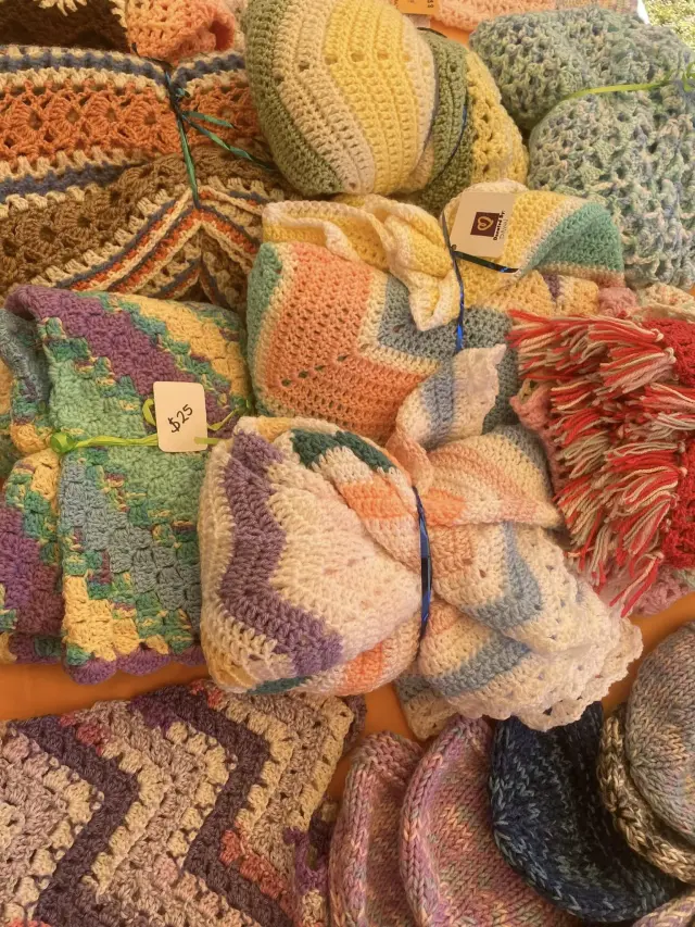 Pile of hand-knitted beanies and blankets