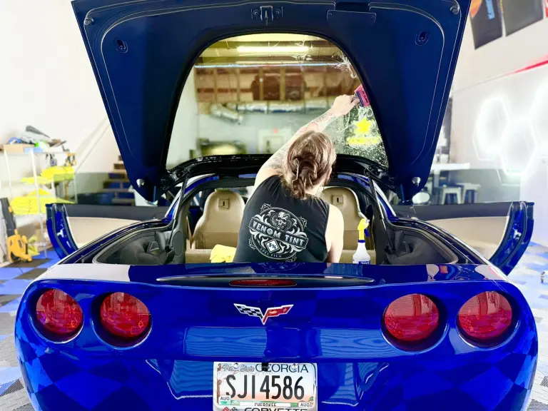 Venom Tint owner installing automotive window film on a Corvette