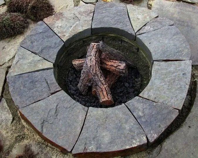 Round flagstone fire pit set into a stone patio