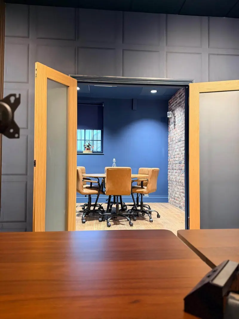 The meeting room, seen through its doors from the dedicated desks