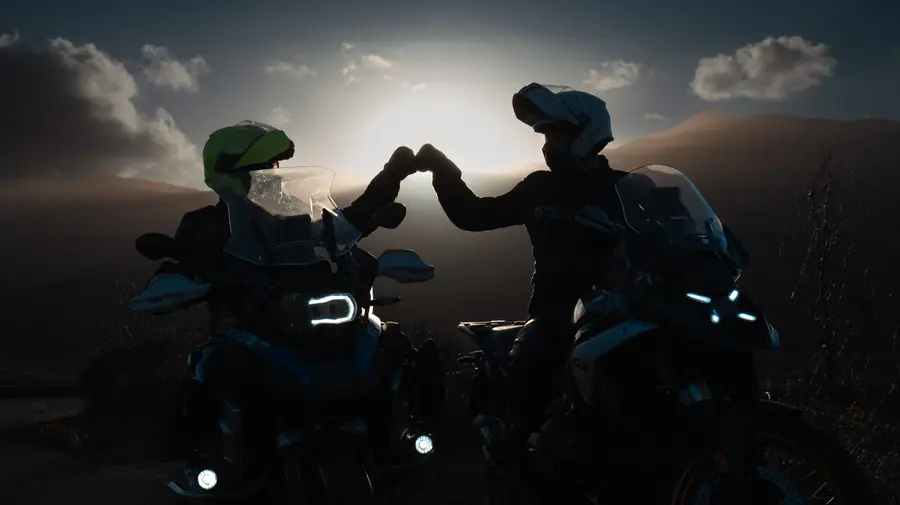 Due motociclisti si salutano al tramonto