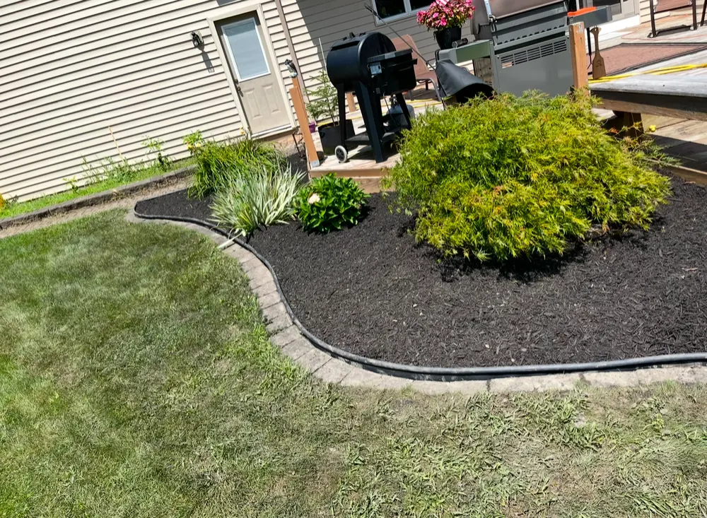 Curved bed with paver edging and fresh mulch beside a patio