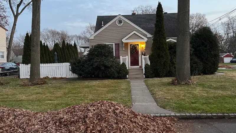 Same yard with leaves cleared to the curb
