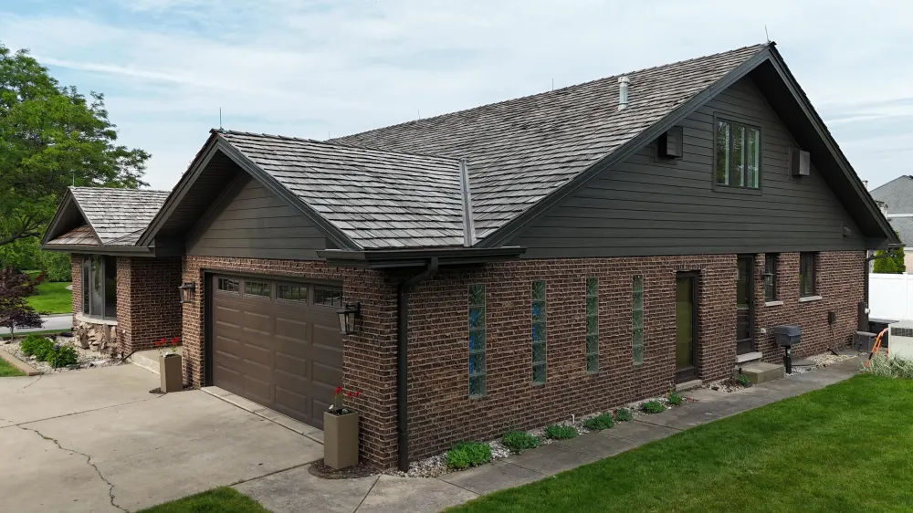 Northwind Exteriors roofing project with dark roof and brick home