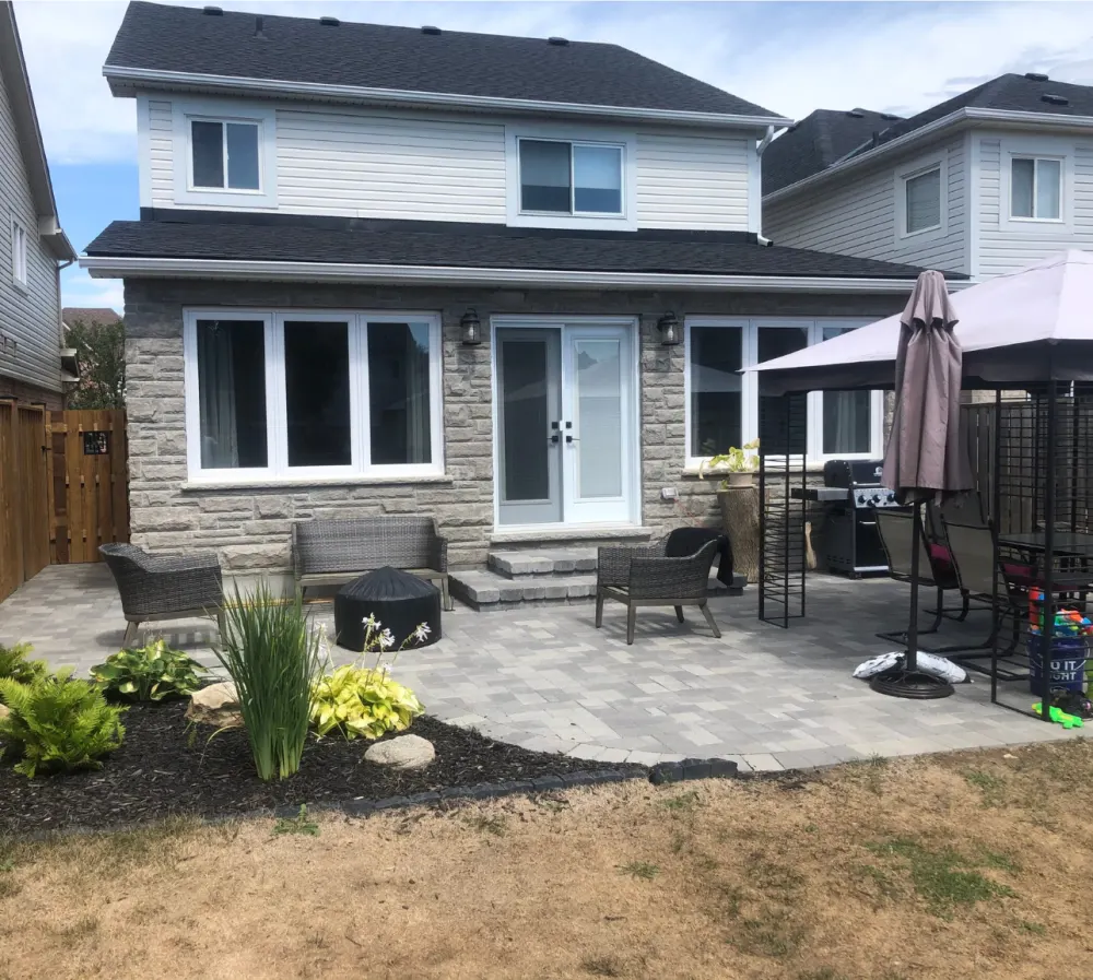 Stone clad rear elevation with a new paver patio and planting beds