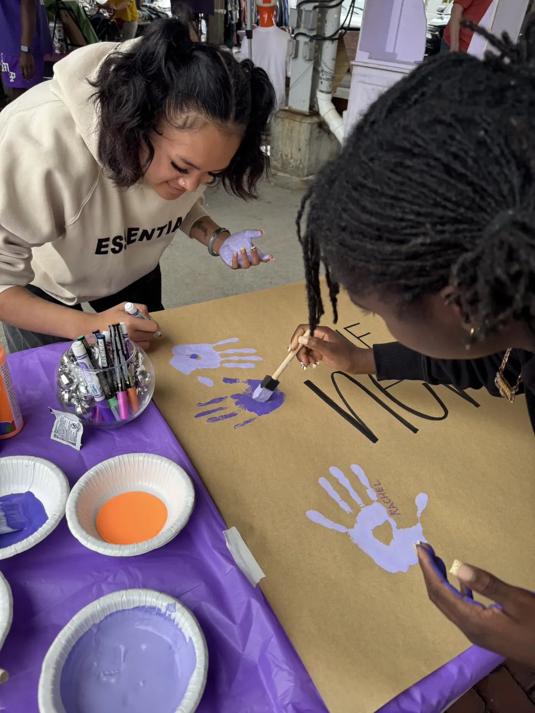 Guests creating a colorful community handprint mural