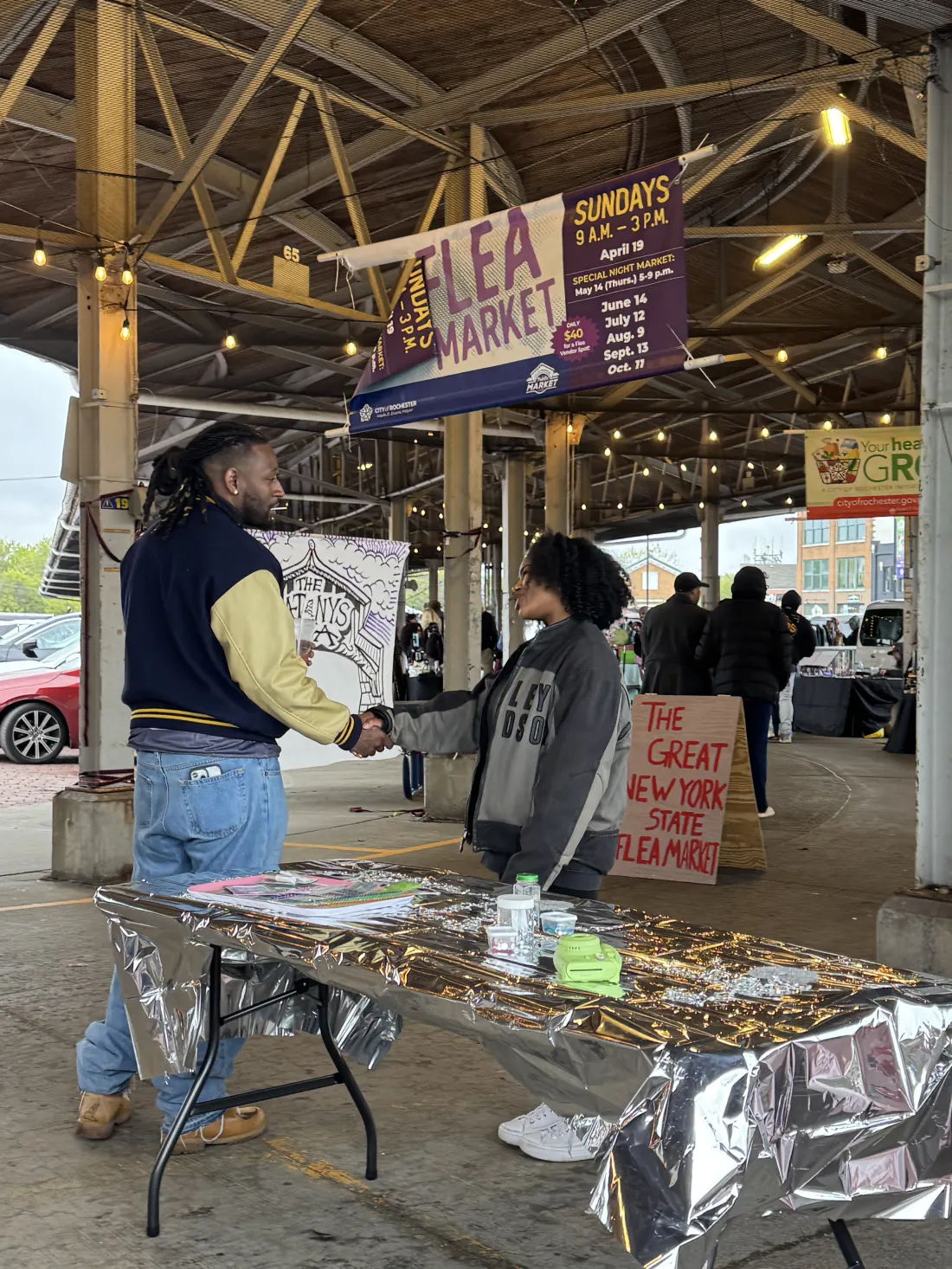Market banner above tables filled with vendors and finds