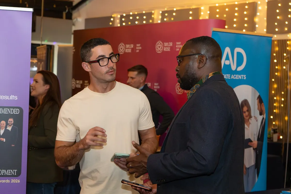 Two guests talking by the exhibitor stands at Archive, Leeds
