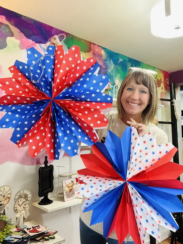 Beth holding colorful paper fans in her studio