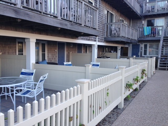 Picket fencing along condo patios by All Fenced In