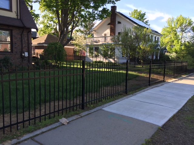 Black aluminum fence at a street corner by All Fenced In