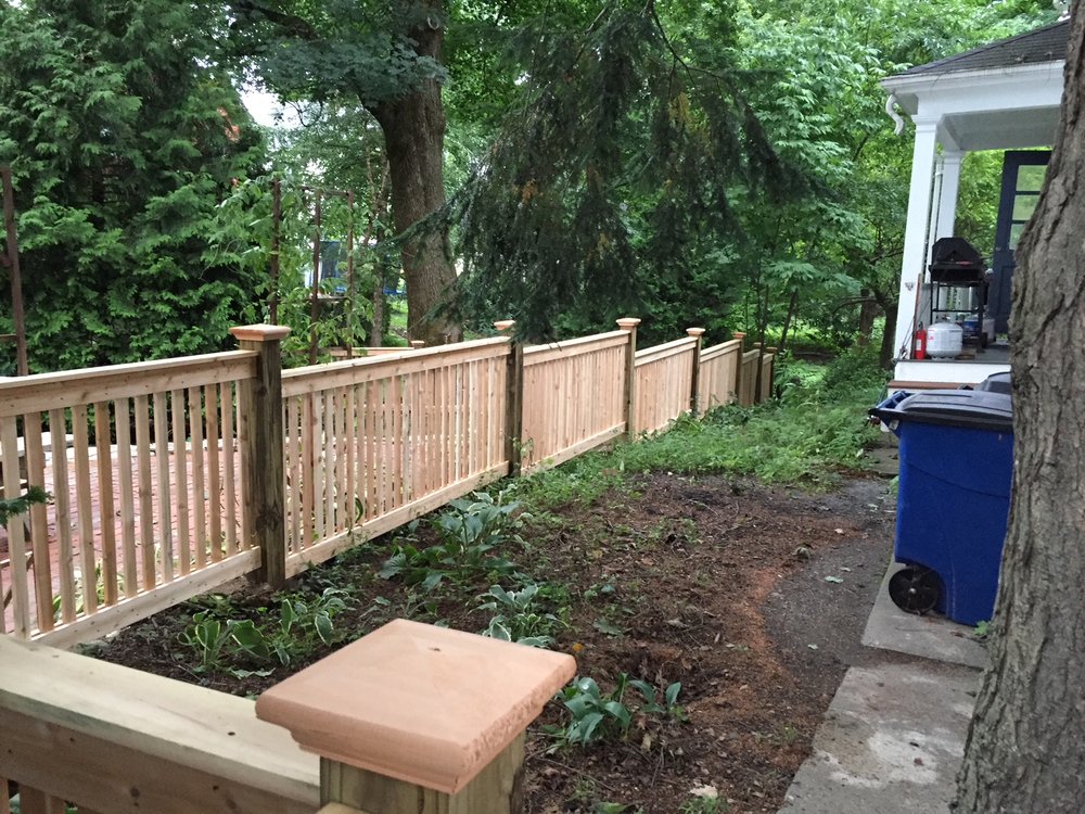 Wood railing fence above a stone wall by All Fenced In