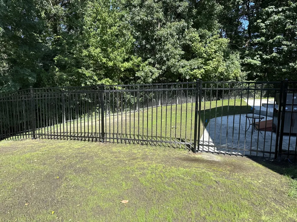 Black aluminum fence on a sloped backyard by All Fenced In