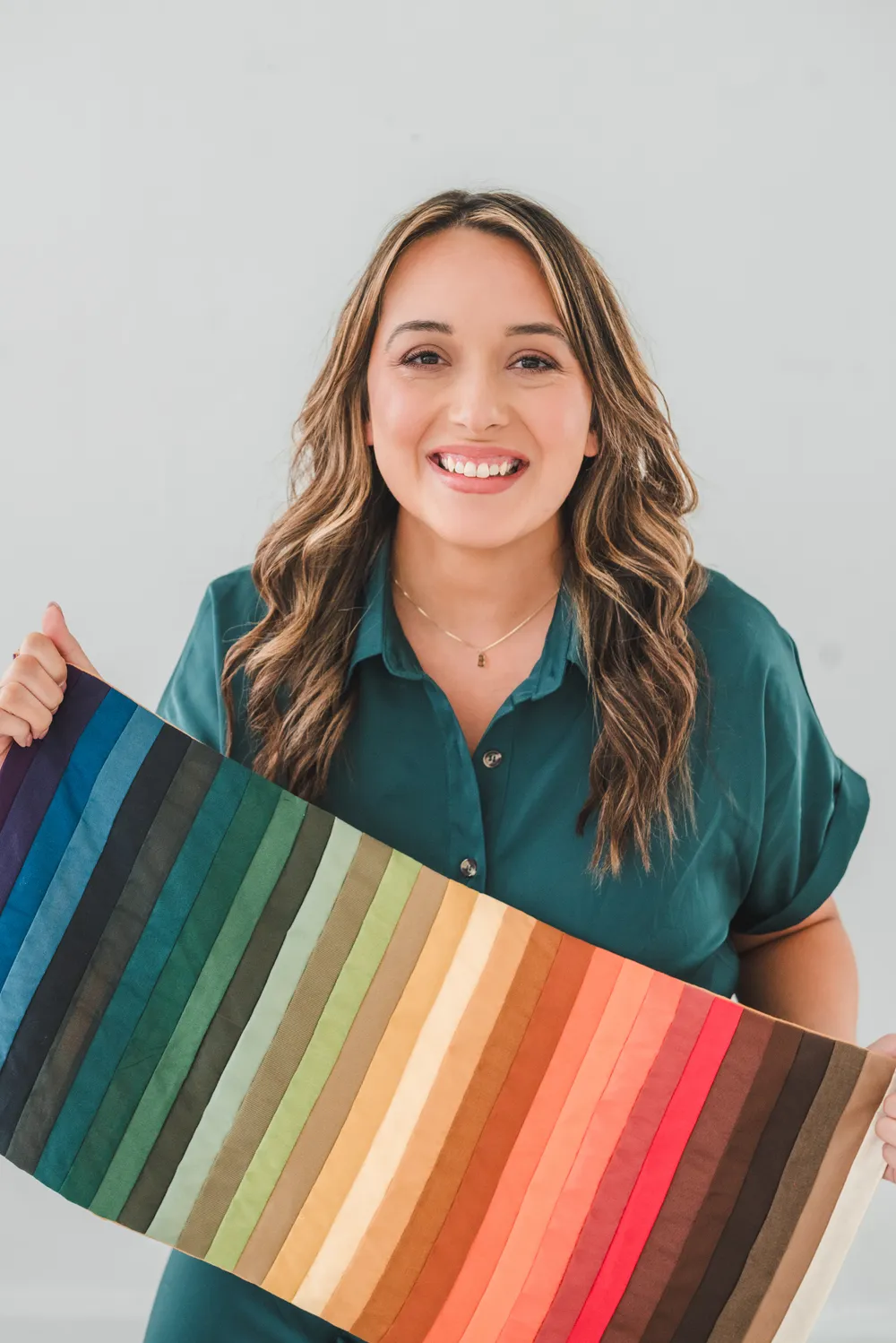 Bethany Brenneman smiling and holding a long drape of color swatches