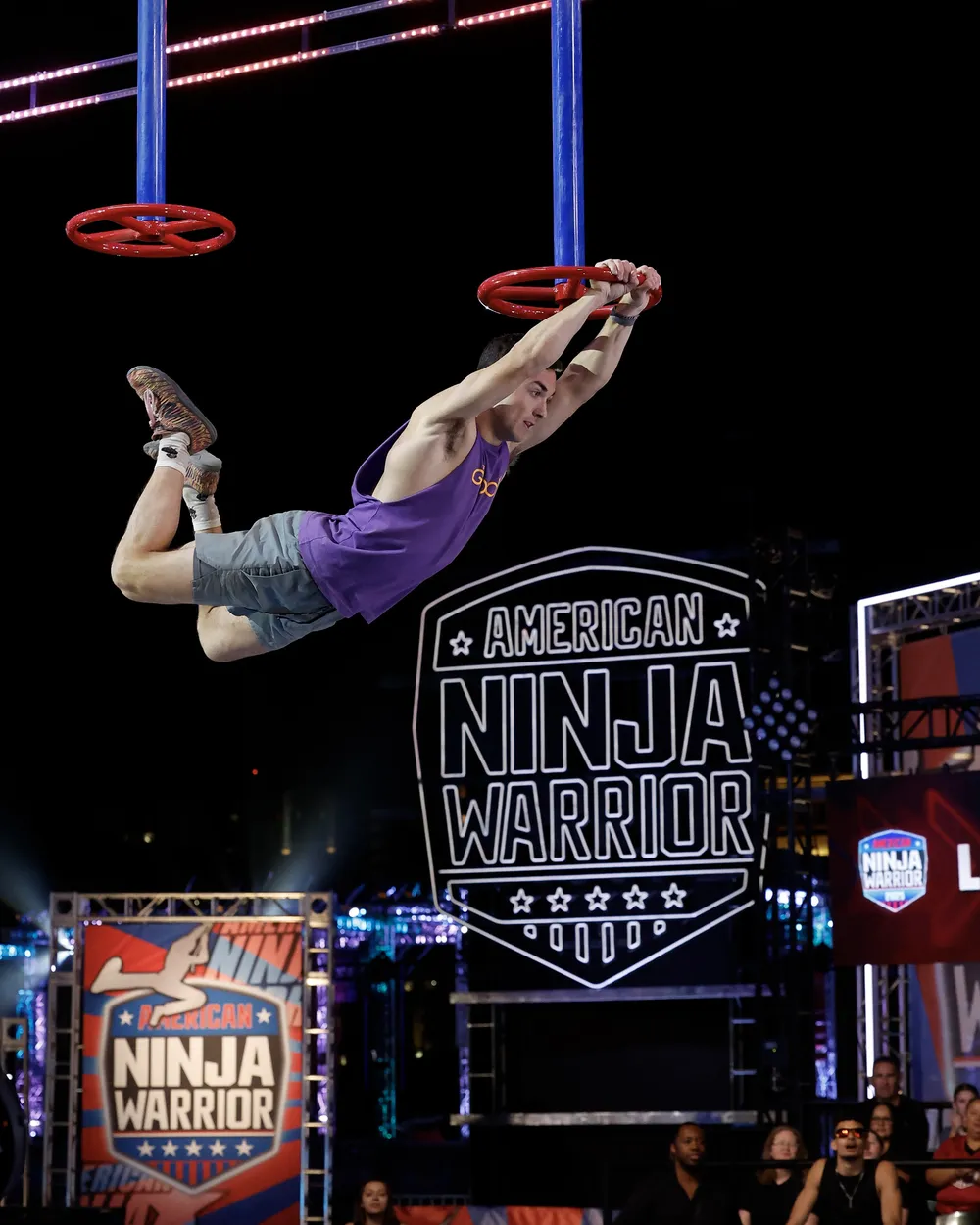 Jonathan Godbout swinging between ring obstacles on American Ninja Warrior