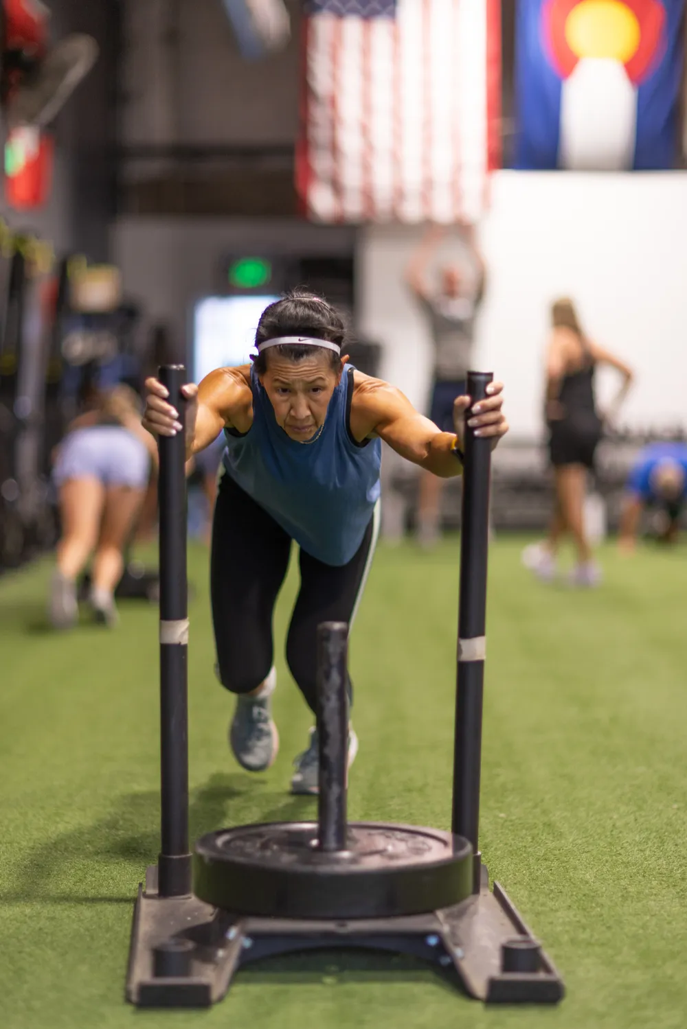 Member pushing a weighted sled during a coached session