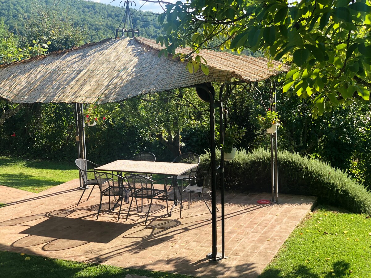 Shaded outdoor dining table in the garden at Villa Pregiata
