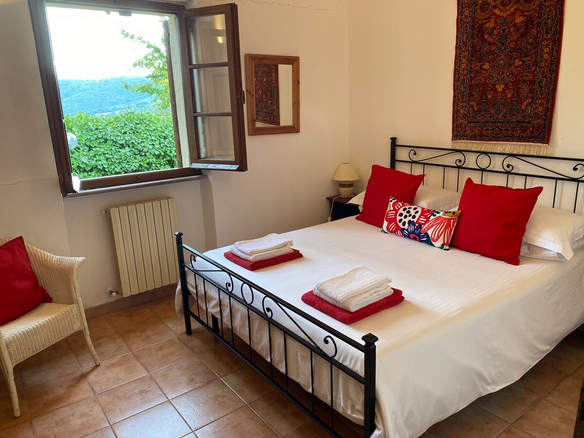 Double bedroom with an open window overlooking the hills