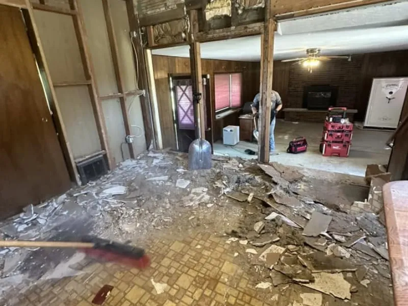 Room with torn-out flooring and construction debris ready for removal