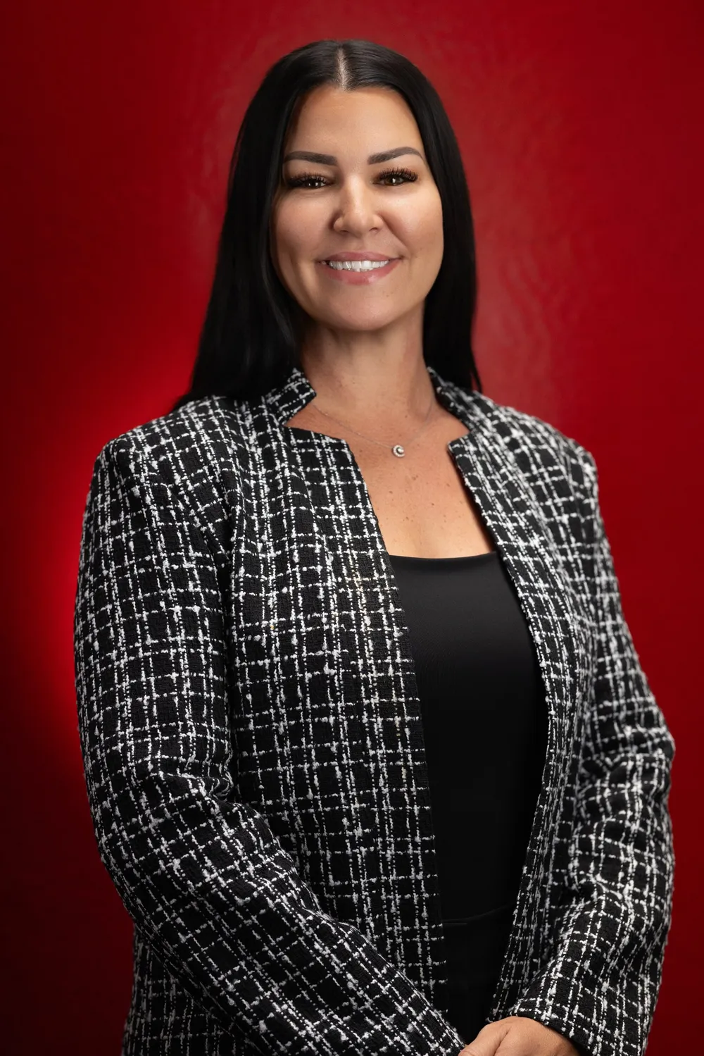 Devon Dean, owner of Style City Salon & Spa, smiling in front of a red backdrop
