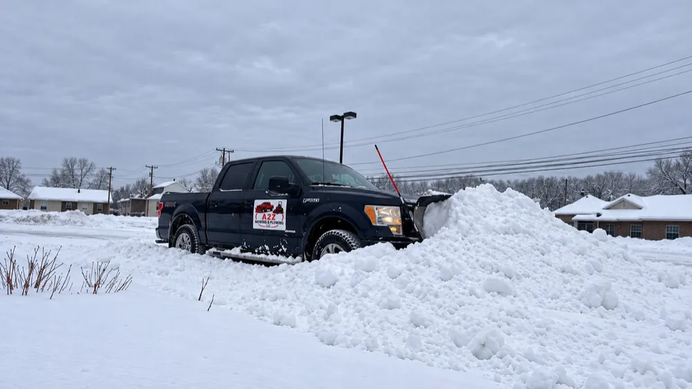 A plowed lot with the snow banked to the side by the A2Z truck