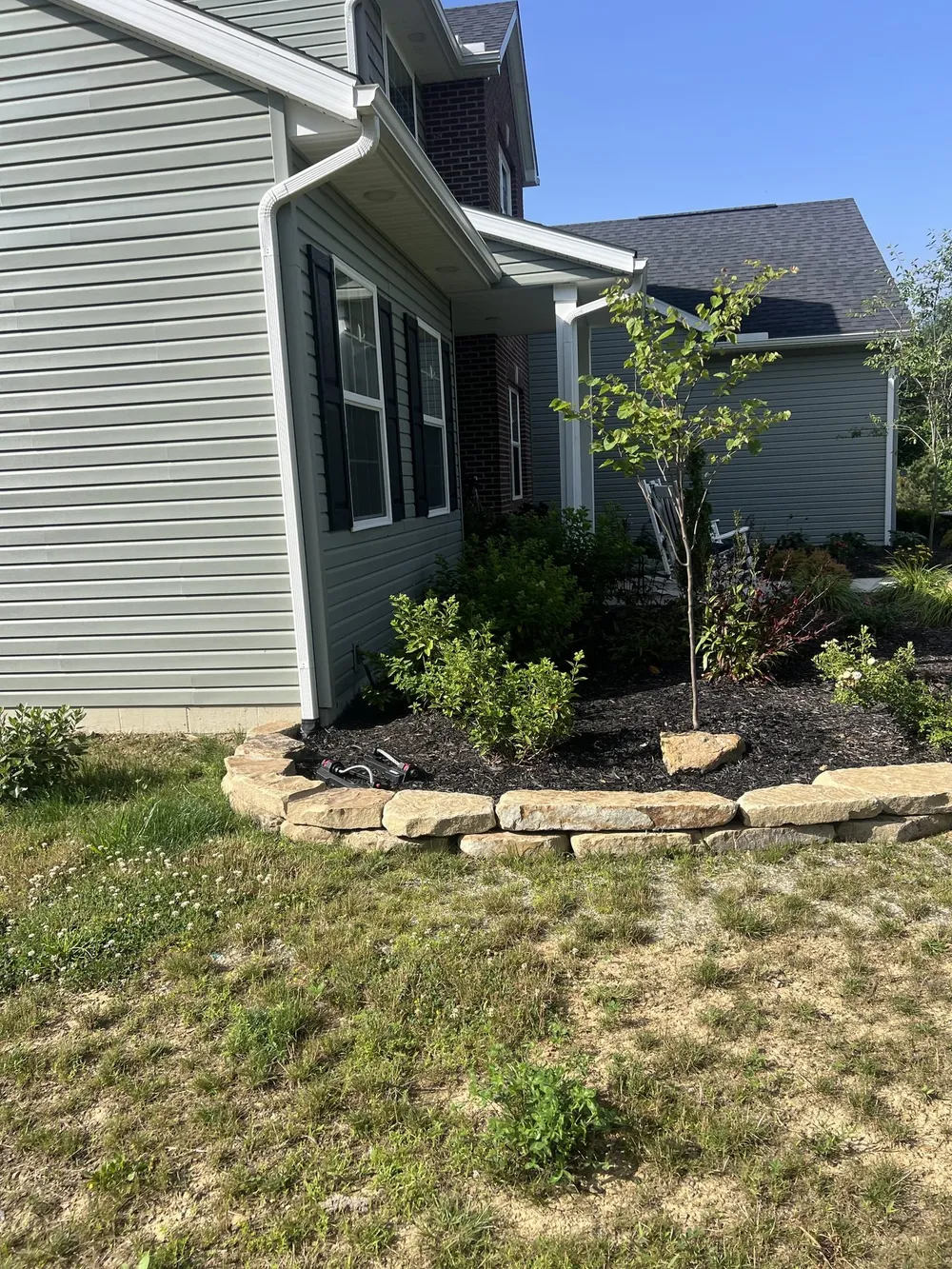 A clean edge between dark mulch and landscaping stone