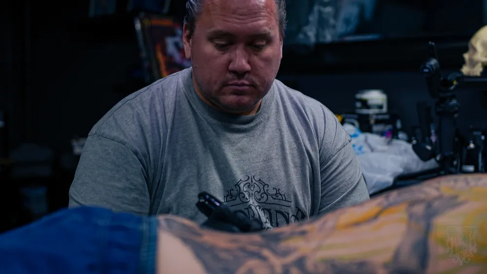 Mickey tattooing a client