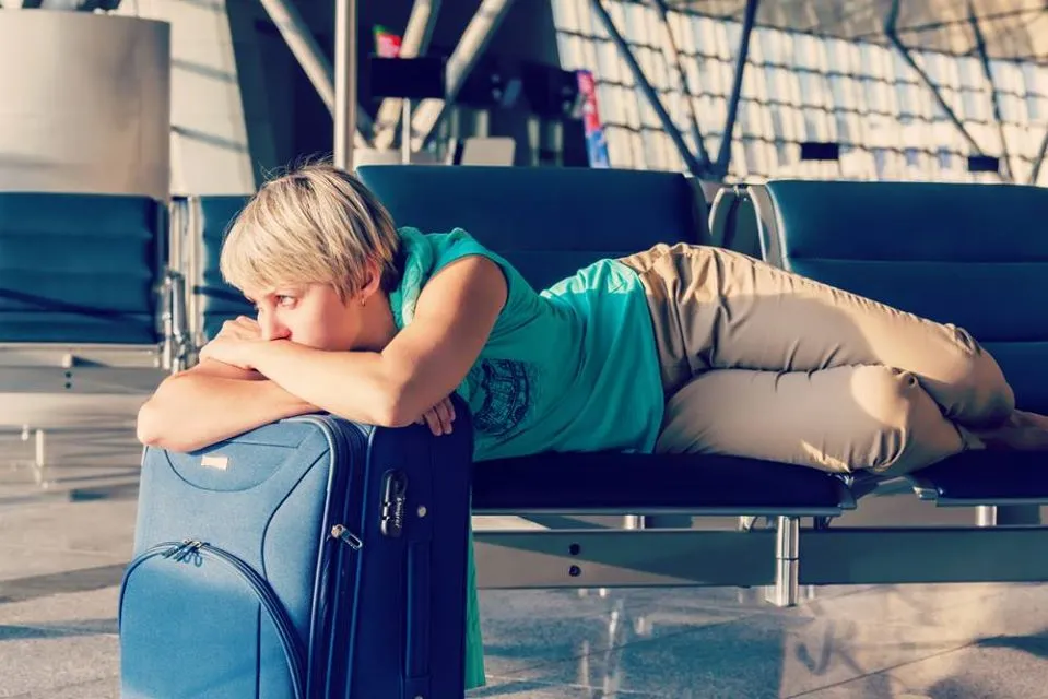 Tired traveler waiting at the airport - skip the bus with The Shuttle