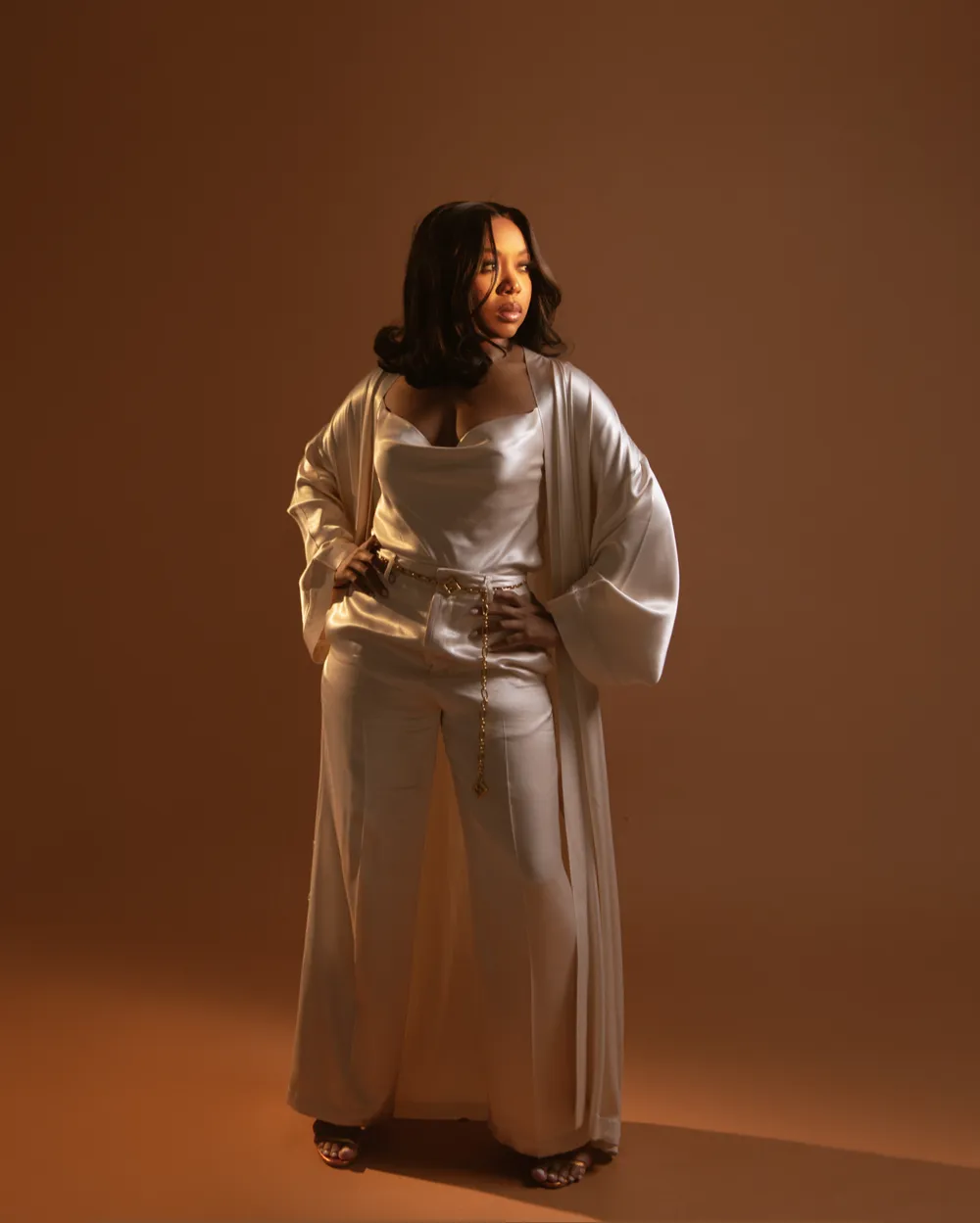 YaYa, Licensed Esthetician and founder of Vivify Body & Co. Aesthetics in Brooklyn, NY, in a white satin set