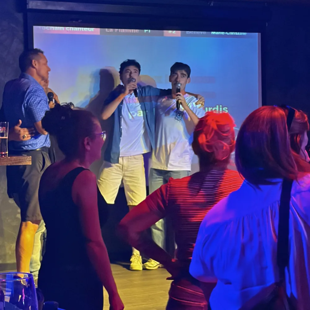 Participants chantant au micro lors d'un party de groupe au Pop