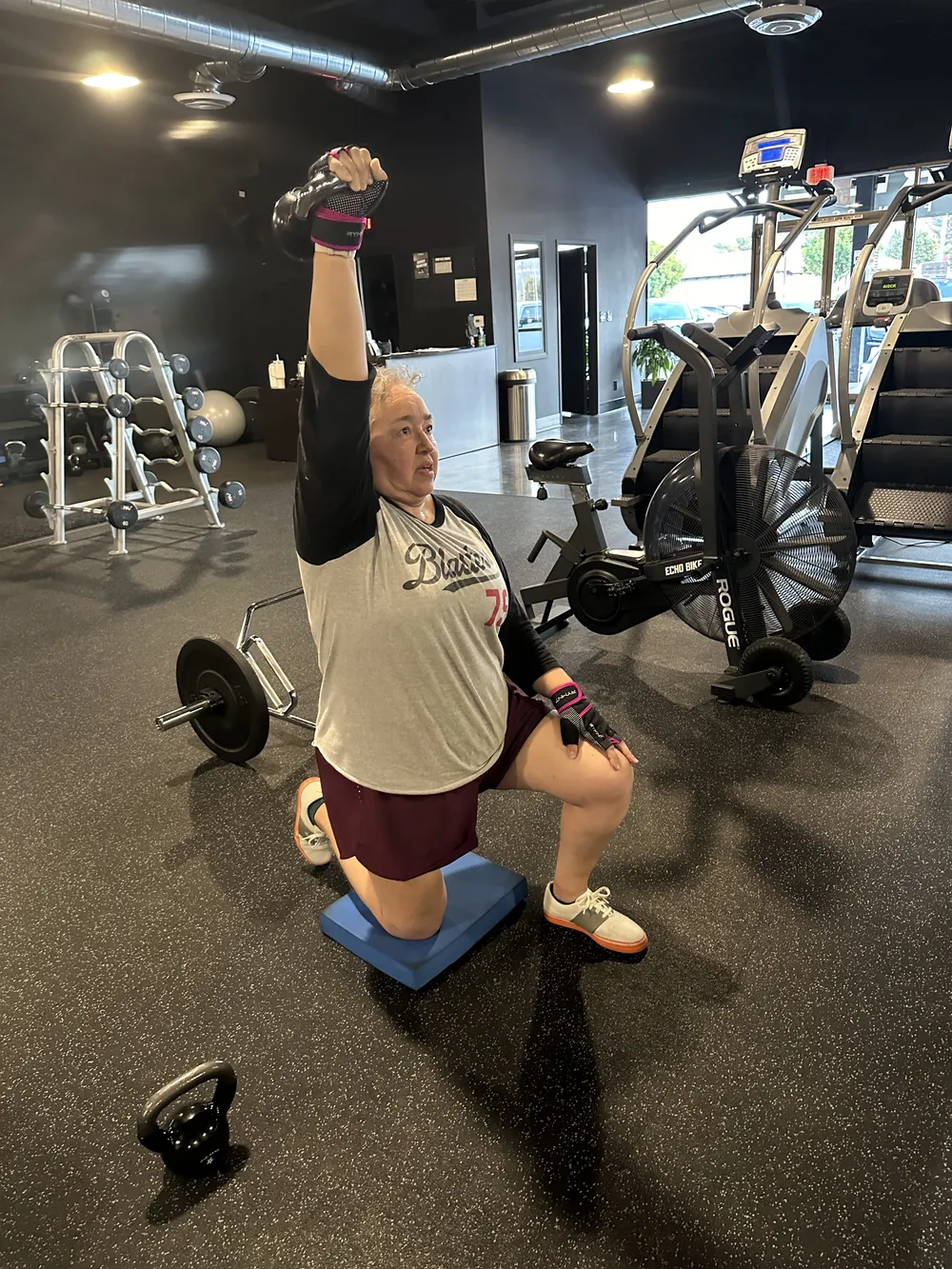 Client doing a kneeling overhead press