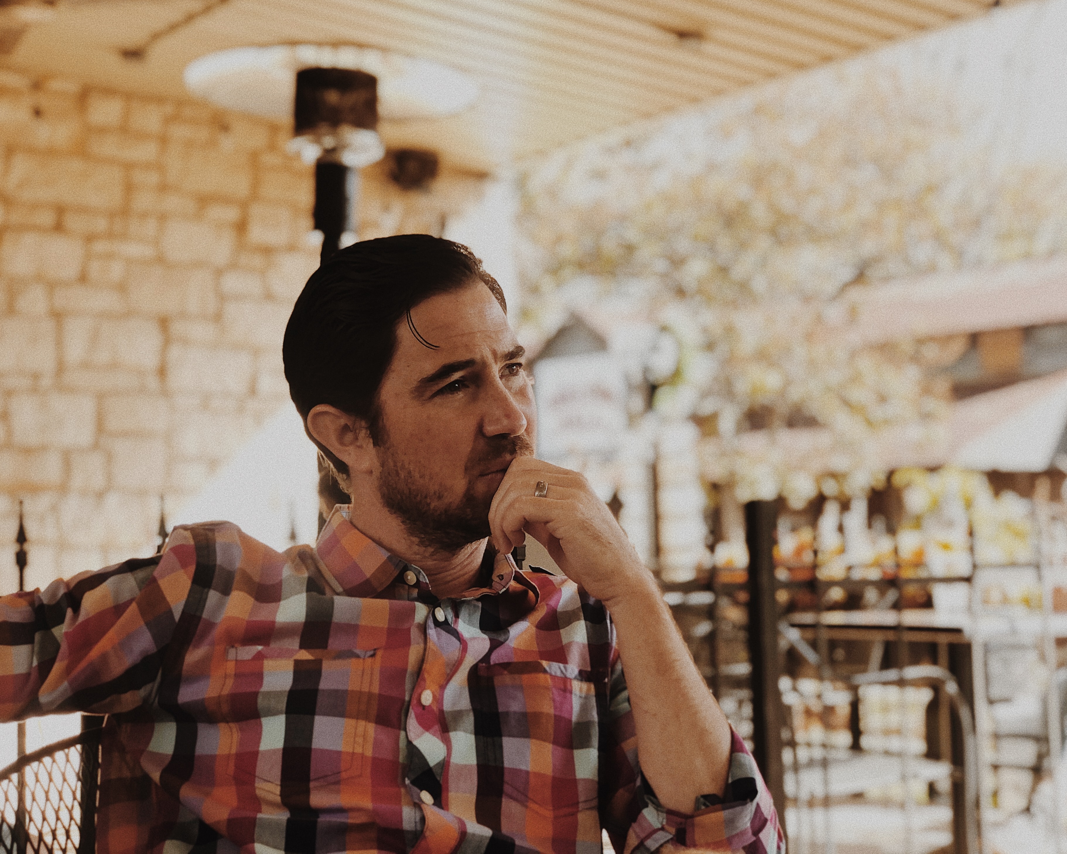 A man in an orange plaid shirt reflecting
