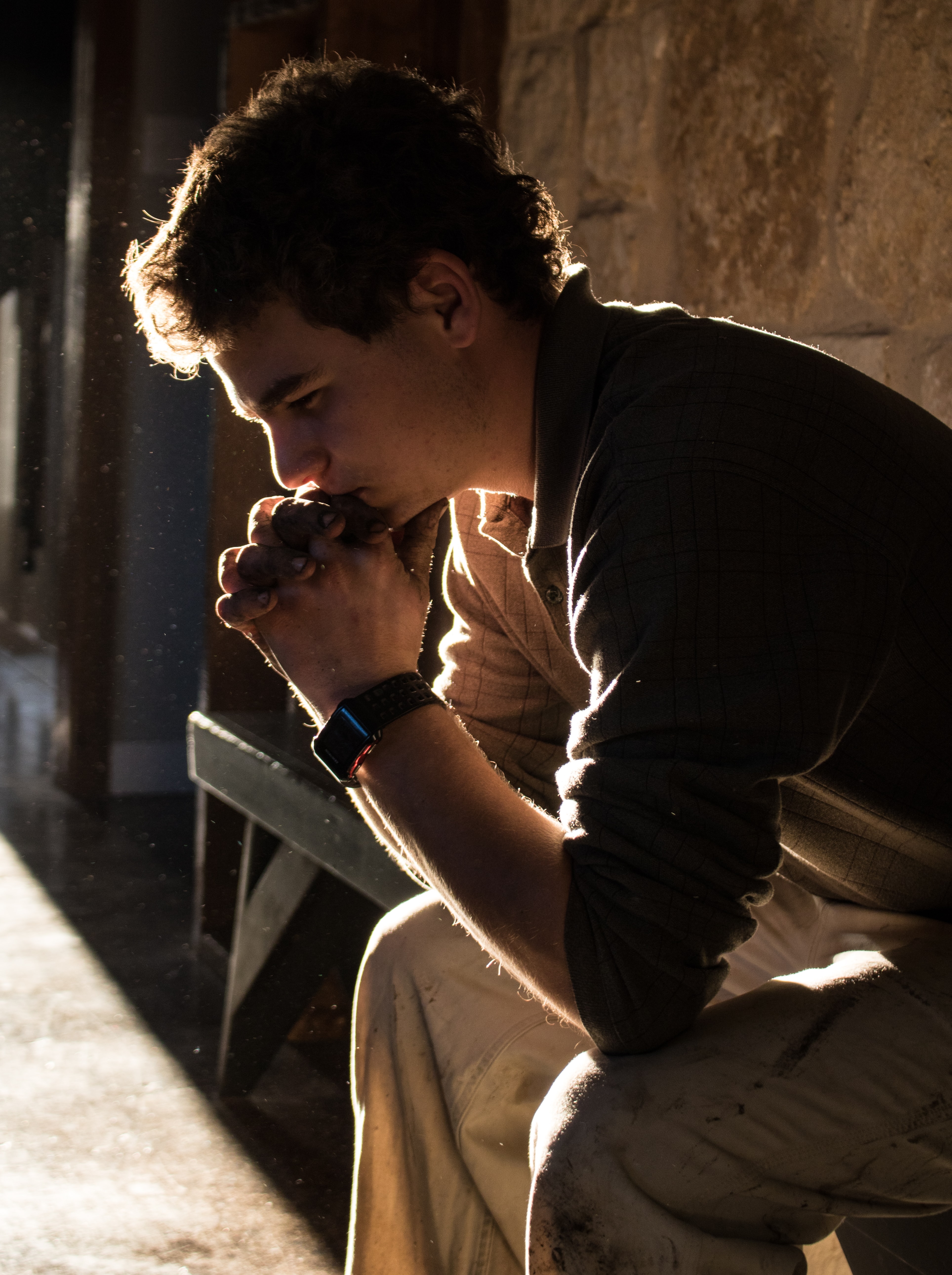 A man sitting quietly with his hands clasped
