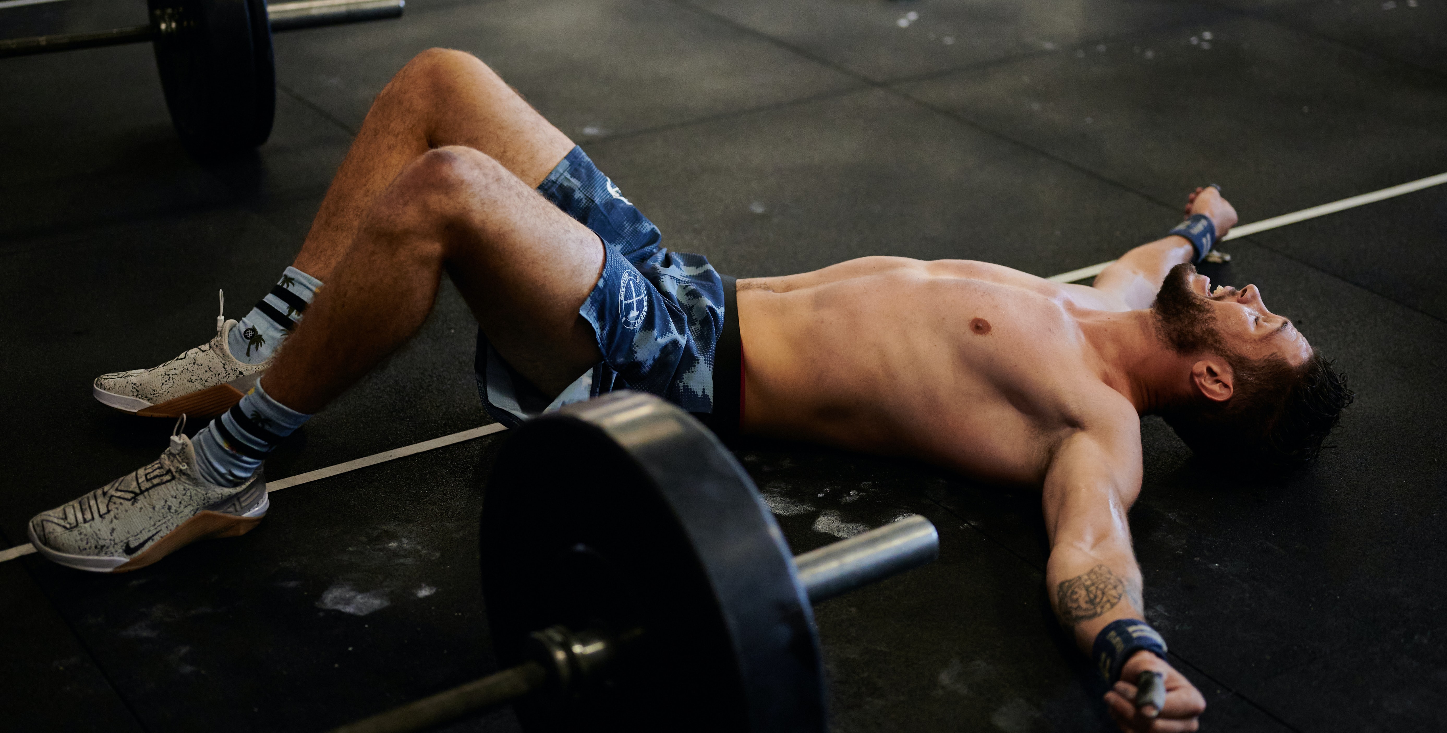 A man resting on the gym floor after a workout