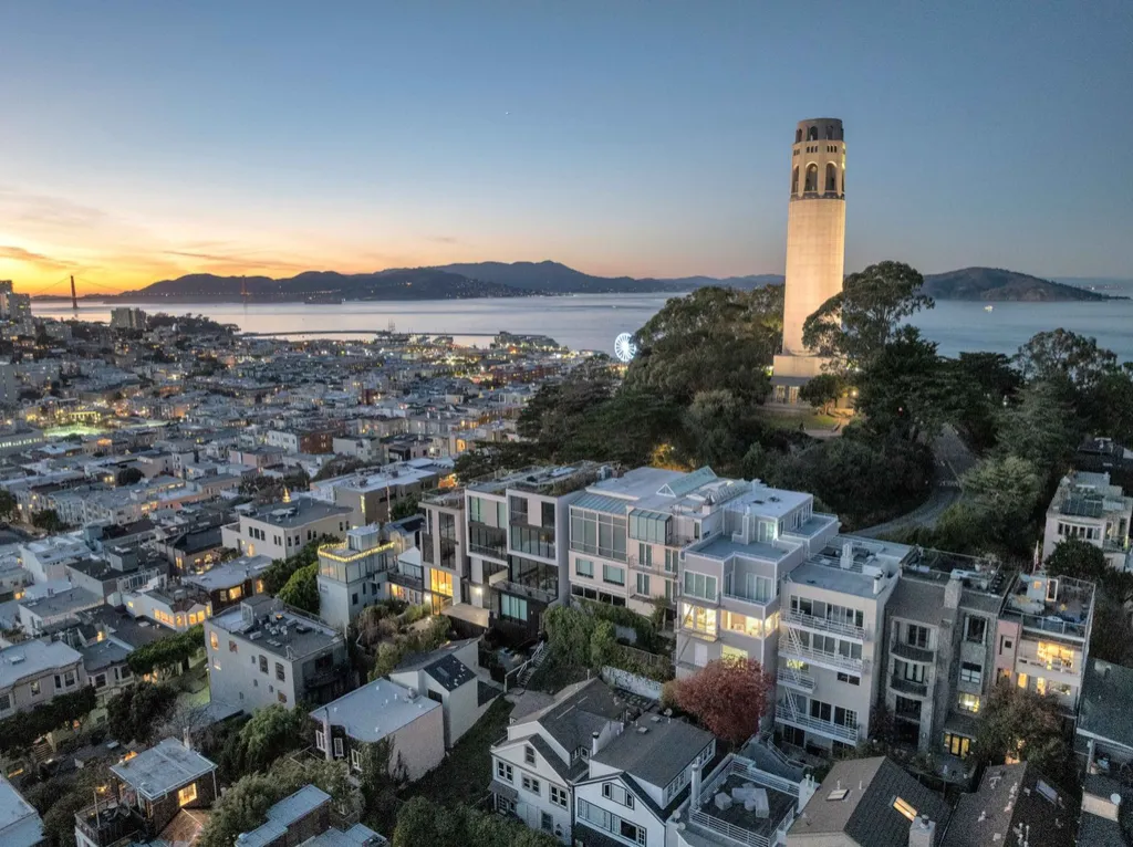 Twilight drone photo over Telegraph Hill and Coit Tower toward the bay