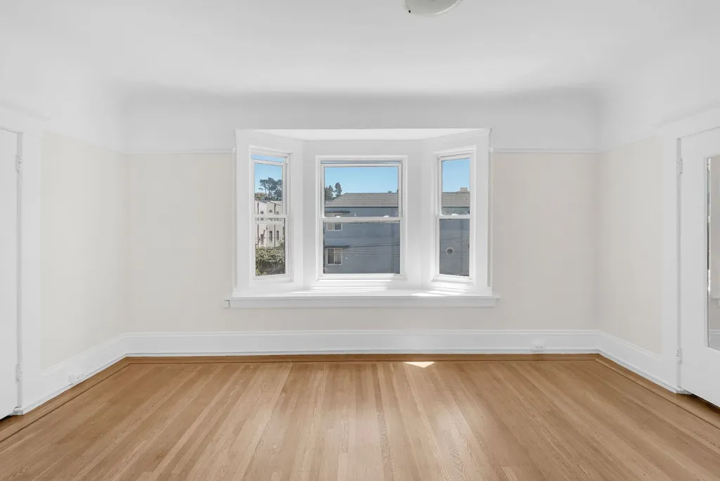 Bedroom with a bay window and hardwood floors