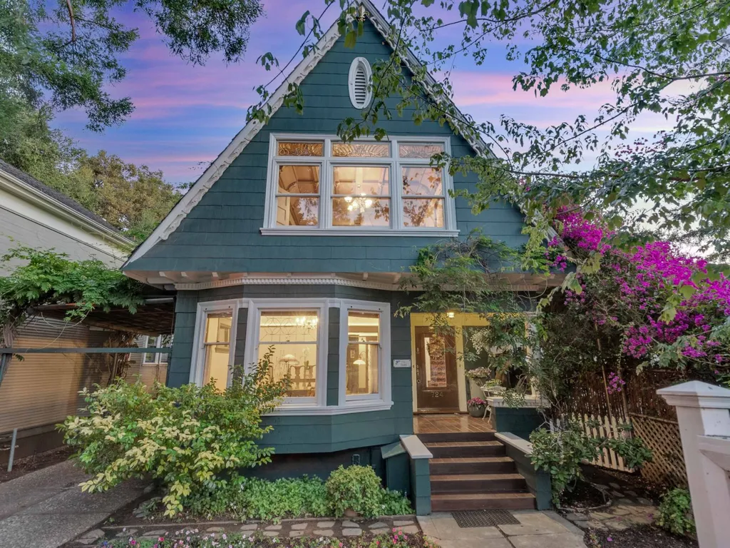 Twilight photo of the front of a Palo Alto home with its windows lit