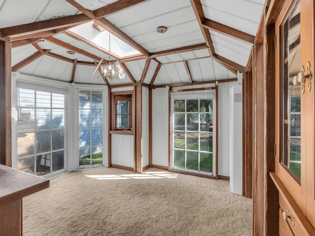 Room wrapped in windows under an exposed beam ceiling