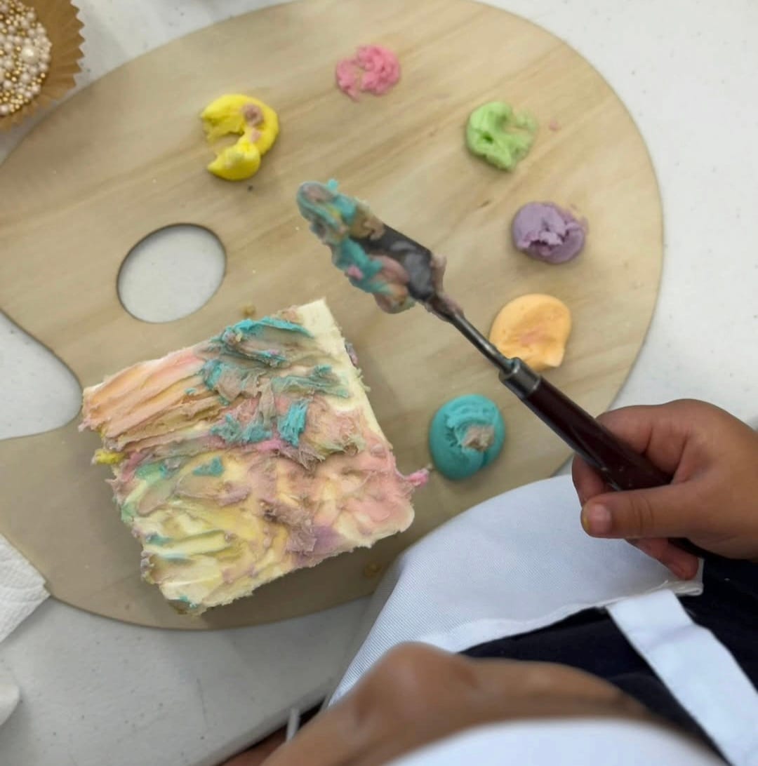 Kids decorating a rainbow birthday cake slice