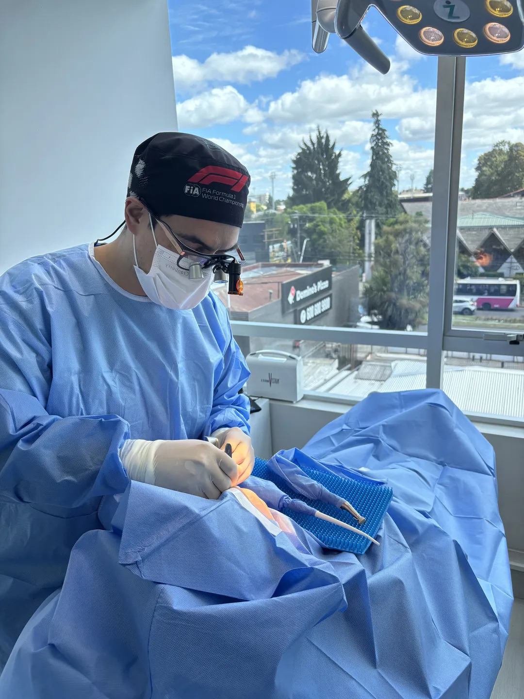 Dentista de Pravara con ropa quirúrgica durante un procedimiento en la clínica