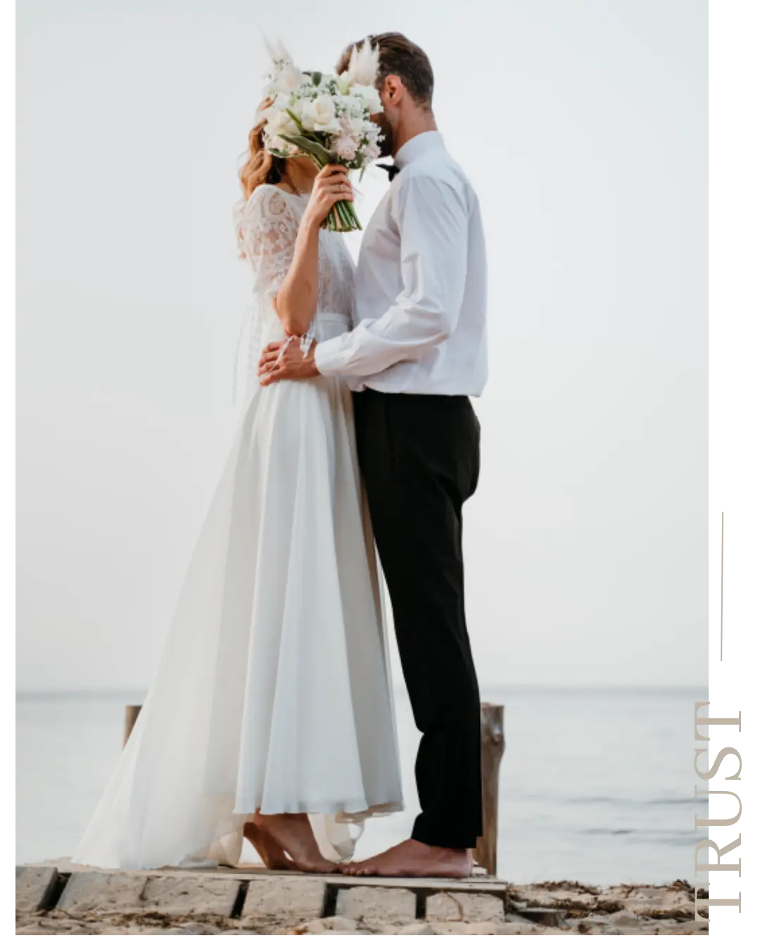 Couple enlacé au bord de l’eau avec un bouquet de mariée blanc